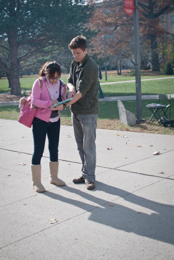 Gavin Moore, senior in philosophy and co-president of ActivUs,
stops students in front of Parks Library on Friday, Nov. 4, to
inform them about the Beyond Coal campaign and his groups petition
to get ISU administrators to form a long-term plan to phase out the
use of coal on campus.
