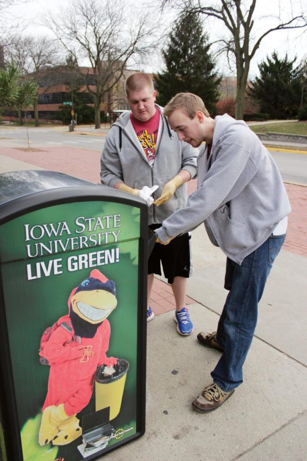 Tyler Cox, junior in pre-business, and Thomas Lutz, sophomore in
industrial design, both members of Sigma Pi fraternity, clean out a
solar-powered trash compactor outside of Kildee Hall on Nov. 13 as
a part of Sigma Pi's Altruistic Campus Experience Project, which
aims to keep campuses clean through volunteer work. 
