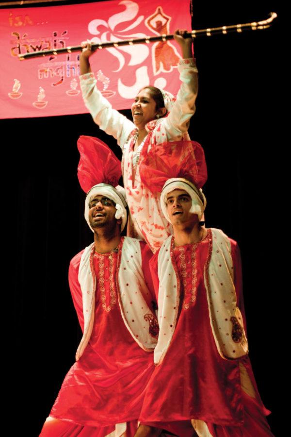 Shraddhesh Anavkar, sophmore in achitecture, and Rajin Olson,
senior in civil engineering, support Manali
Patel, sophomore in chemistry (corrected from Sapna
Madia, sophomore in kinesiology and health), at the end of
the Bhangra, the traditional Punjabi folk dance they performed to
finish Diwali Night on Saturday, Nov. 5. Diwali Night 2011 is an
Indian Students Association event that was held in the Memorial
Union Great Hall.
