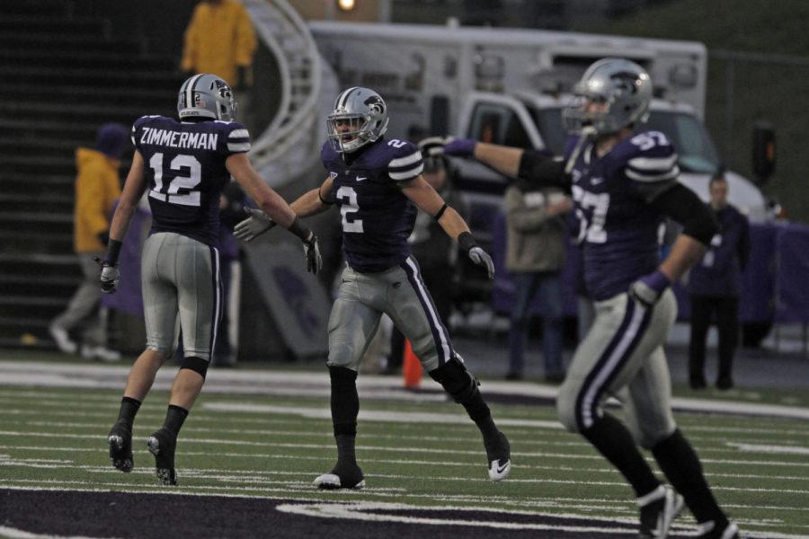 Members of the Kansas State defense celebrate after forcing a
turnover on Iowa States final offensive possession to seal a 30-23
win. The Wildcats forced two Cyclone turnovers to hold on to the
win and finish the season 9-3.
