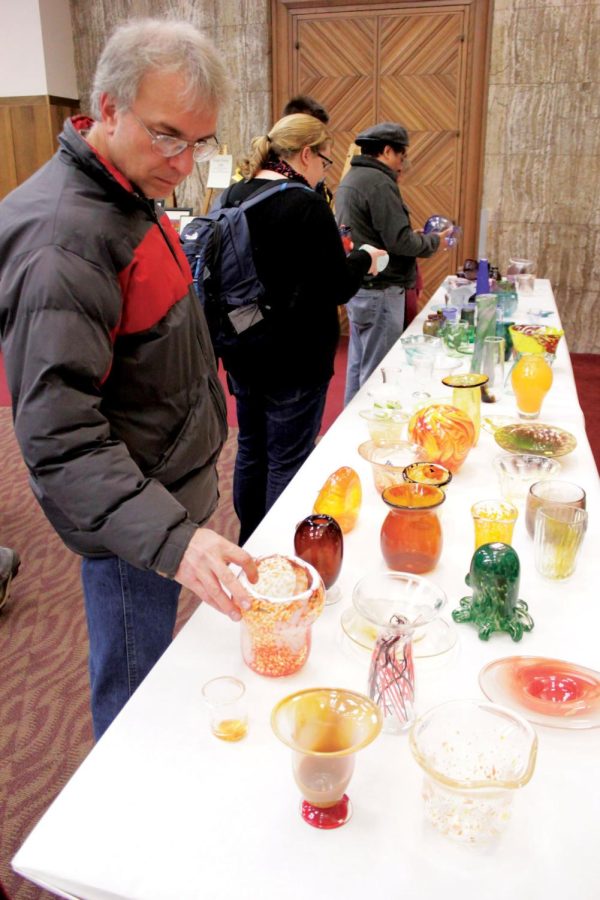 Visitors to WinterFest's Art Mart in the Memorial Union examine
blown glass pieces crafted by local artists on Friday, Dec. 2. The
art sale featured the works of ISU students as well as members of
the community. Among items offered for sale were ceramic tea sets,
lithographic prints and wearable art such as scarves and
hairpieces. 
