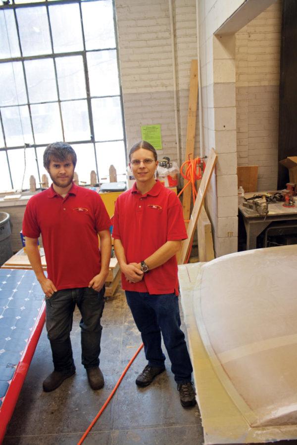 Project director Evan Stumpges, right, and assistant
project director Dakota Morgan of PrISUm stand between the the last
solar car the team made and the one in progress on Sunday, Jan. 22,
in Old Sweeney Hall. The team will be competing against other
student solar car teams with the new car in the 2012 Formula Sun
Grand Prix in July.
