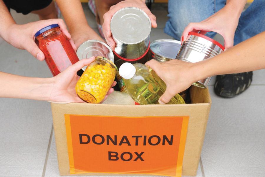 People putting food in a donation box
