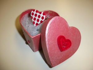 This easy DIY makes for the perfect Valentines Day gift.
Step 1: Pick out a button to put on the ring. A candy sweetheart or anything that is flat on the back also will work.
Step 2: With a hot glue gun, attach the button to the ring.
Next, create the box:
Step 1: Paint the box with red or pink acrylic paint.
Step 2: Embellish the box with anything — use buttons, rhinestones or glitter. Scrunch up tulle ($2.99 at Hobby Lobby) into the box and set your ring inside.
