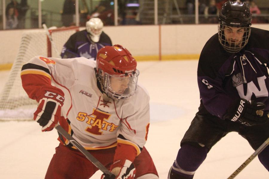 Freshman forward Mark Huber fights for the puck against an aproaching Waldorf defender Friday, Feb. 25, at the Ames/ISU Ice Arena. The Cyclones ended the night with 48 shots on goal compared to Waldorf's 20.
