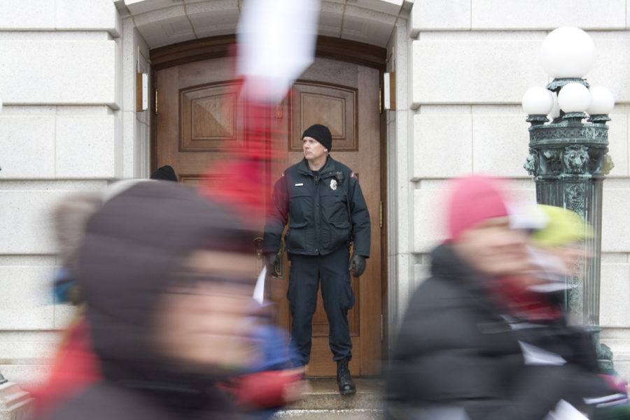 A Wisconsin police officer stands outside of a capitol building door on Monday, Feb 21, to keep people from entering emergency exit only doors as they march past. The protesters often thanked the officers for doing their job. 