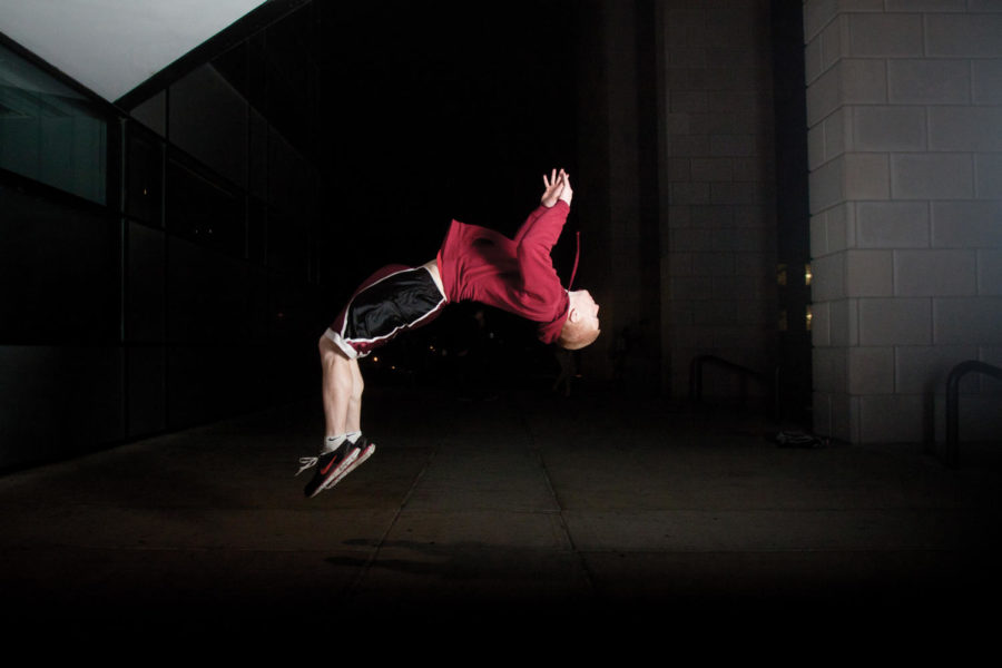 Nick Smith, junior in liberal arts, does a backflip outside of Parks Library on Tuesday, March 20. 
