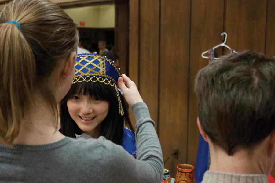 Xiaoxiao Wang, junior in food science, tries on traditional Russian attire during Global Gala on Friday, March 23, in the Sun Room of the Memorial Union.
