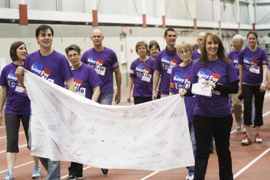 Cancer survivors lead the first lap of Iowa State's Relay For Life while holding a banner full of messages of support Friday, March 23, at Lied Recreation Athletic Center. Survivors were identifiable by special purple T-shirts as well as bandanas bearing their names. 
