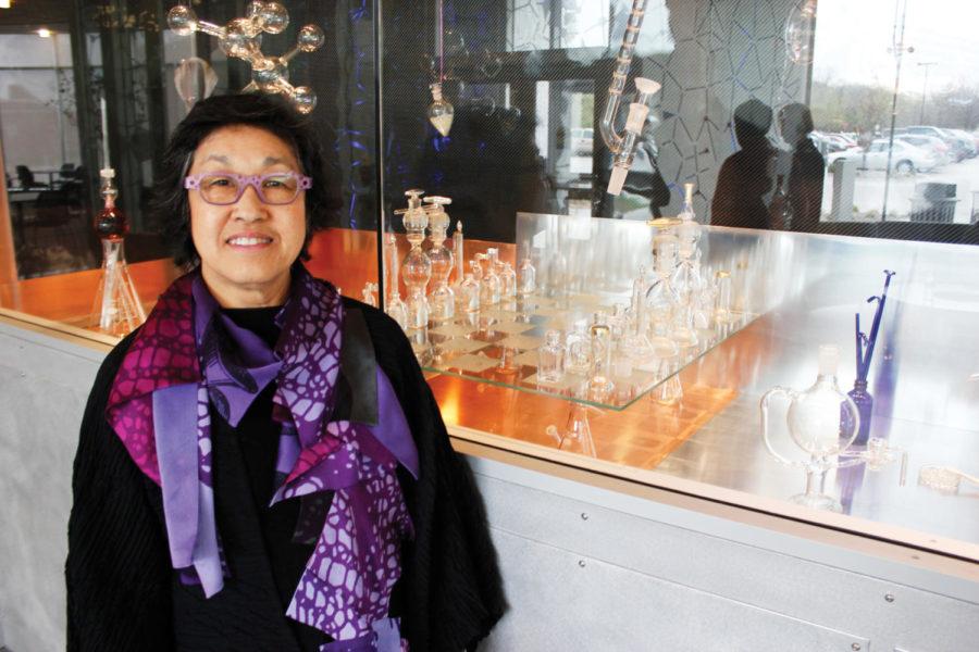 Seattle-based artist Norie Sato poses with a portion of her piece e+l+e+m+e+n+t+a+l, a chessboard coposed of mainly labratory glass in Hach Hall on Wednesday, April 4. All other ornamentation in addition to the glass is made up of copper and zinc, among other elements, hence the name of the work. A reception for Sato was held on Wednesday evening to honor her contributions to art on campus which can be viewed at Hach Hall and the Palmer Building. 
