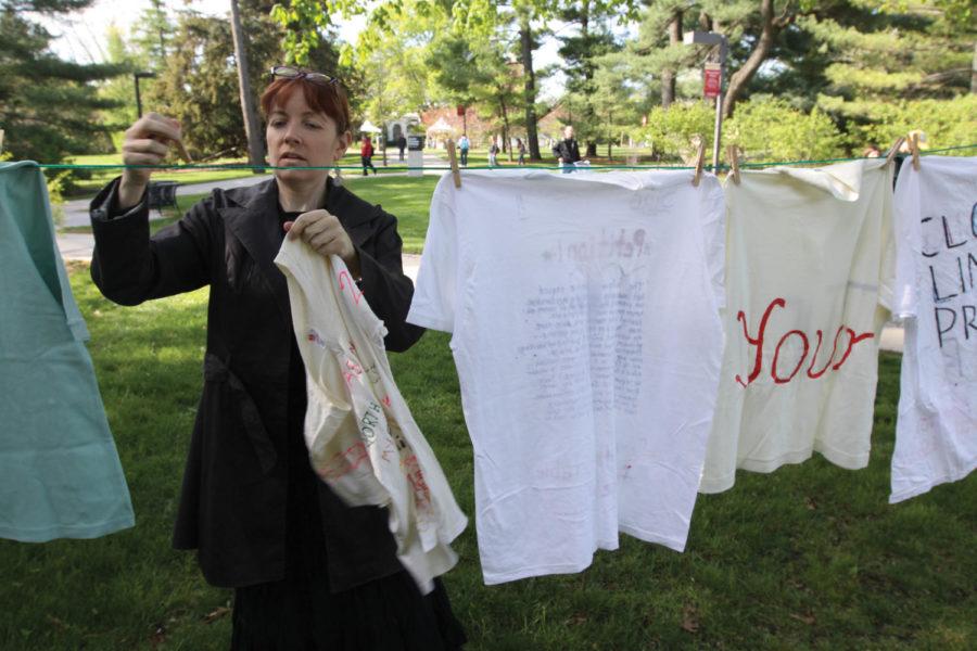 Stacie OConnor hangs up T-shirts designed by survivors, family or friends of survivors of violence on Tuesday, April 17, on the West Lawn of the Sloss Hall. The Clothesline Project provides healing for survivors of violence, and strengthens the awareness of the public about violence.
