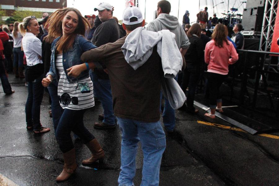 Laura Beaver, senior in family consumer science education, and Tony Cox of DeWitt, Iowa dance to music over the loudspeaker in between sets at Live @ Veishea in the Molecular Biology parking lot on Saturday, April 21. Rather than hiding from the rain, Beaver and her friends danced to keep warm. 
