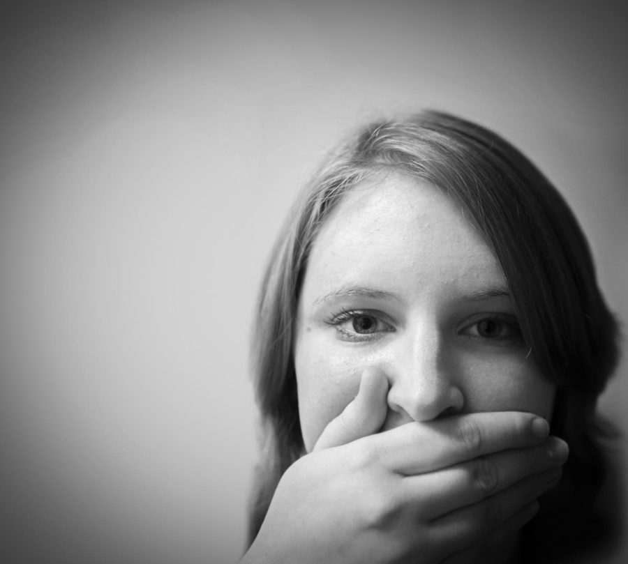 Hollie Butcher, senior in psychology, poses with her hand over her mouth for the National Day of Silence.
