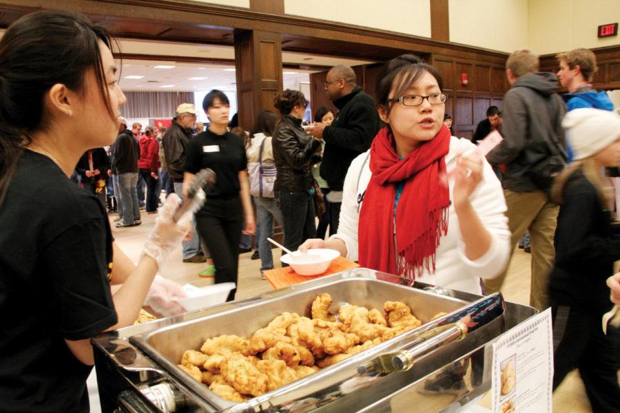 Vy Nguyen, graduate student in chemistry, asks Cezlynn See, senior in chemical engineering, about the Malaysian food at the International Food Fair on Saturday, April 21, in the Memorial Union. The International Food Fair was brimming with people pushed shoulder to shoulder for the food.

