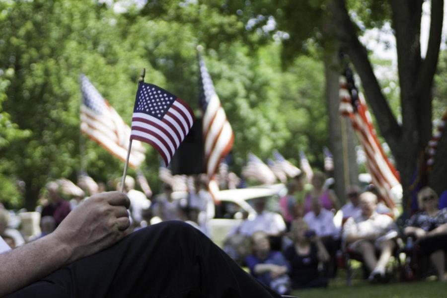 A man holds a flag during the Memorial Day ceremony at Ames Municipal Cemetery on Monday, May 28, 2012. The City of Ames had a parade and memorial service for Memorial Day.
