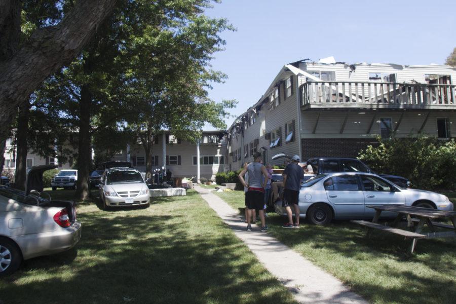 Tenants of 301 S. Fifth St., one of the South Meadow apartment buildings, move their belongs out of the water and fire damaged apartments on Monday, July 16, the day following a fire that caused significant damage to the building.
