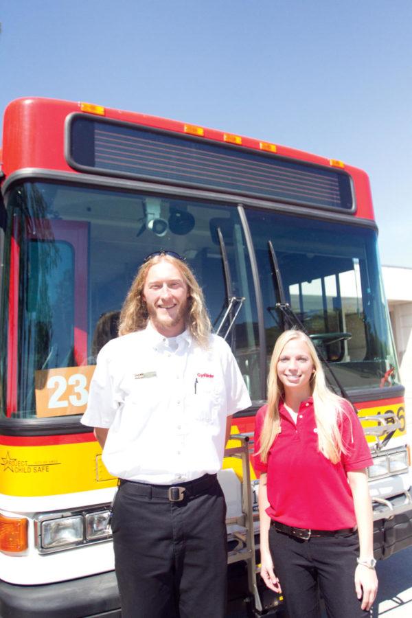 Nathan Shiminek and Amanda Veen pose next to a CyRide bus.
