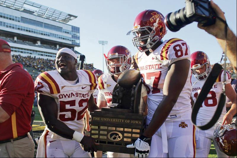 ISU football players show off the Cy-Hawk trophy after winning against Iowa on Saturday at Kinnick Stadium. The win is the second straight for football in the Cy-Hawk series.
