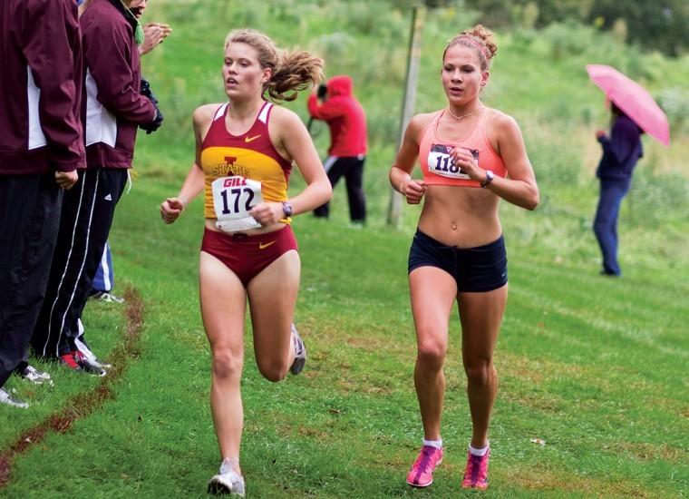 Kellien Oettle, left, and Morgan Casey, right, run neck and neck Saturday during the Iowa Intercollegiate at the ISU cross country course.