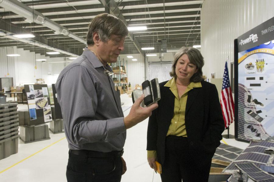 Frank Jeffery, co-founder of PowerFilm, shows Sharon Burke, an assistant secretary of defense, a portable phone charger made by PowerFilm. The company manufactures flexible solar panels that have uses for both the military and civilians. The solar panels are designed to be sewn onto fabric that allows them to be folded or rolled up, saving both space and weight over traditional glass solar panels.
