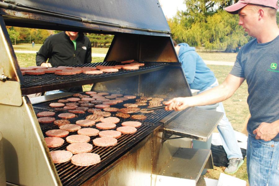 Jimmy Kent, junior in agricultural business, tends hamburgers at one of the two large grills Thursday, Oct. 11, on Central Campus. The College of Agriculture and Life Sciences hosted the weeklong event, which included a free lunch, as part of CALS Week to promote the college.
