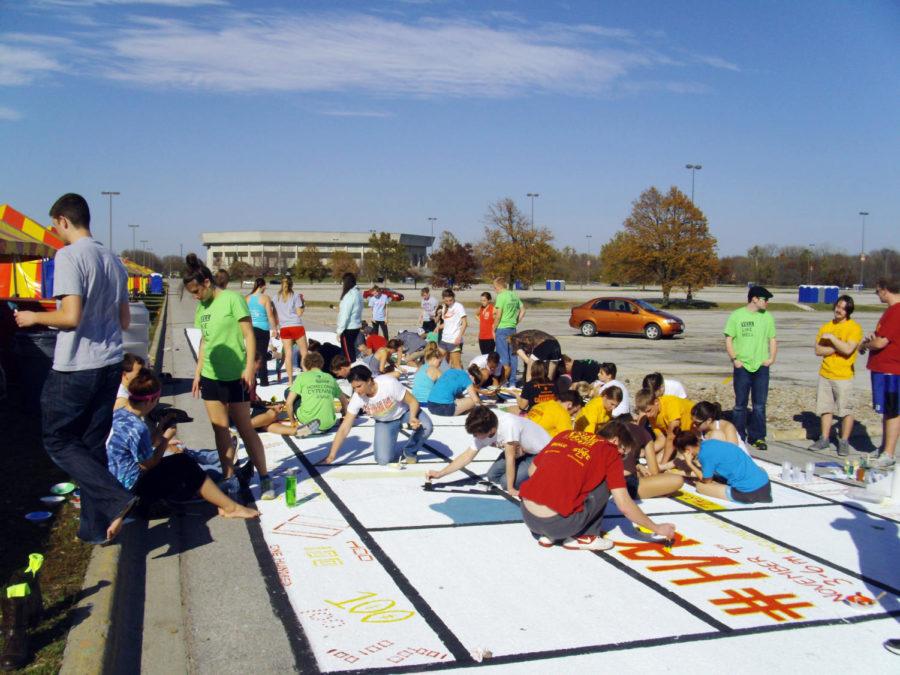 Members of the greek community paint Victory Lane in front of Jack Trice Stadium on  Sunday, Oct. 21, as part of the Cytennial Celebration for the 100th Homecoming at Iowa State.
