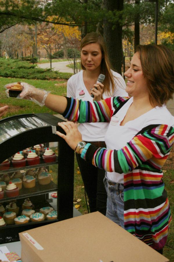 Jessica Muntz, senior in event management, serves a cupcake at the Cupcakes for a Cause event on Wednesday, Oct. 24, near the Campanile. They were helping raise money for Dance Marathon.
