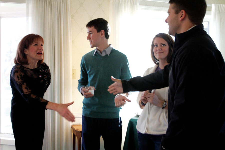 Janet Leath shakes hands with Spencer Vore, senior in accounting, right, while talking to him; Mary Hallman, senior in kinesiology and health; and Jake Swanson, junior in global resource systems, during an open house at the Knoll on Monday, Nov. 26. The university presidents wife prepared hot chocolate and desserts for guests as well as introduced the Knoll. 
