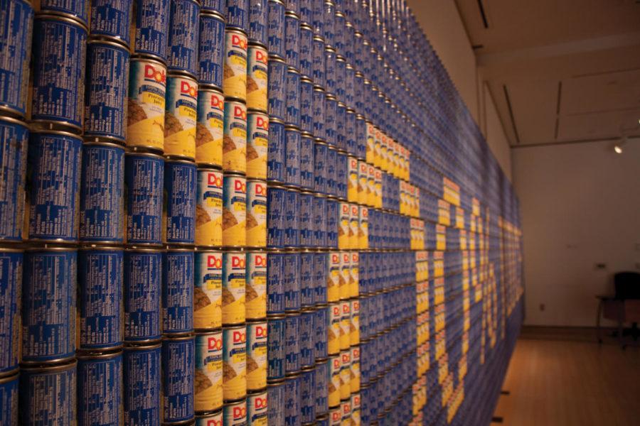 A wall of cans spells out 100% Juice at the Christian Petersen Art Museum, which is currently exhibiting a collection of found-material sculptures created by Andy Magee. The exhibit uses various materials to make a statement about contemporary social issues. 
