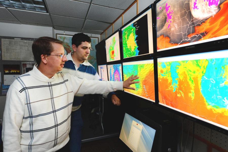 William Gallus, professor of geological and atmospheric sciences, works with Tim Marquis, graduate student, to prepare forecasts for Cyclone football, soccer, softball and track to make sure everyone will be safe on game day.
