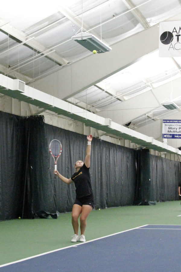Tennis player Ksenia Pronina, sophomore, tosses the ball up for serve against Iowa on Saturday, Jan. 26, at Ames Racquet & Fitness. The Cyclones lost the meet 6-1.
