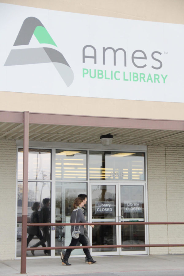 Two citizens walk pass the new temporary location of the Ames Public Library at 620 Lincoln Way on Monday, Dec. 3. The new location is set to open on Monday Dec. 10, while the other building at 515 Douglas Ave. is going under construction for remodeling. The library will be open regular hours.
