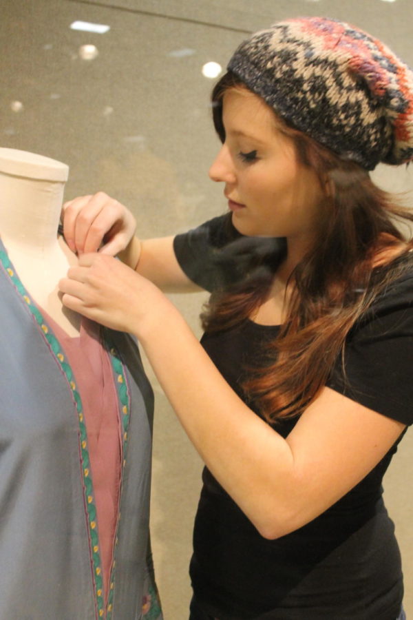A student prepares a garment for an upcoming exhibit at the Textiles and Clothing Museum.
