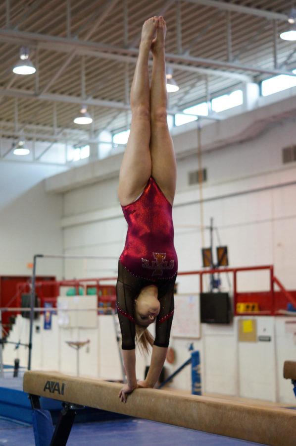 Sara Townsend, freshman in Kinesiology and Health, does a handstand on the beam at Beyer Hall on January 31. ISU Gymnasts have recently seen an increase in injuries on the team.
