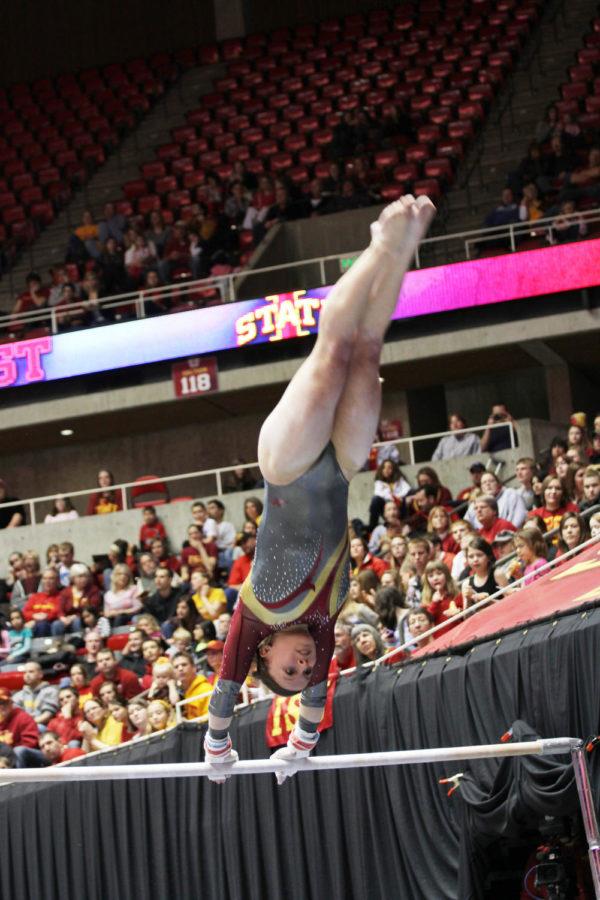 Sara Townsend performs a routine on the uneven bars Feb. 8 during the Beauty and the Beast gymnastics and wrestling meet at the Hilton Coliseum.
