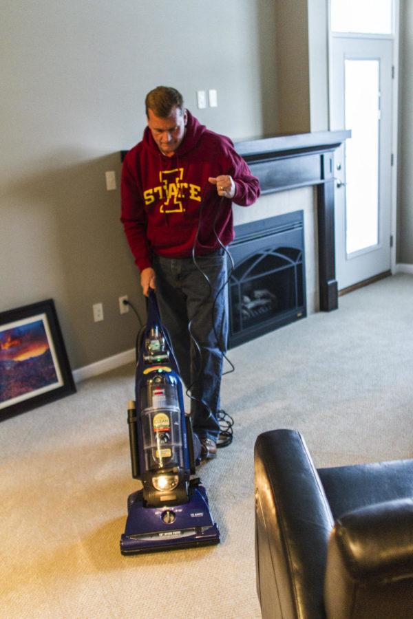 Roger Neuhaus, president of the ISU Foundation, vacuums in his new apartment as he and his family prepare to move in Friday, Feb. 22.
