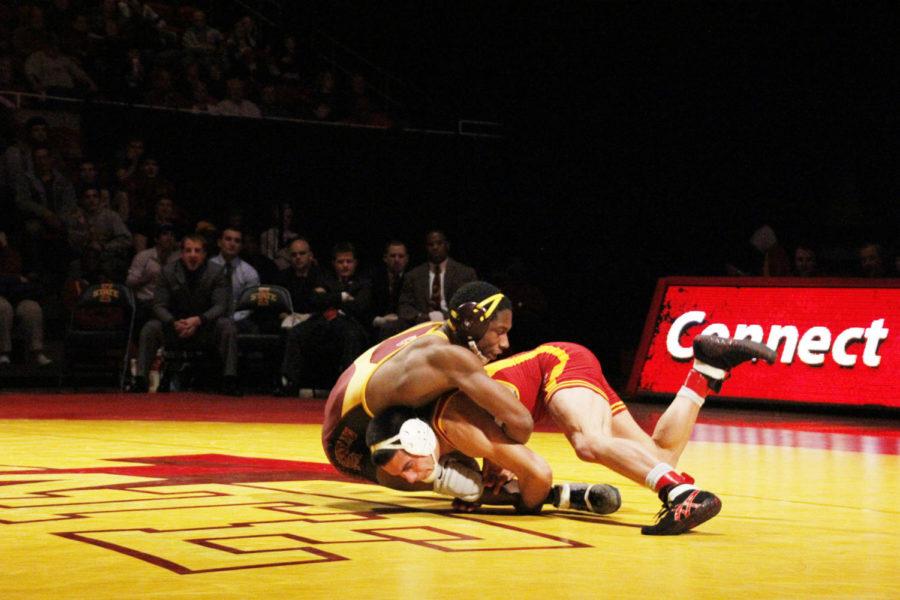 Redshirt sophomore Mike Moreno attacks the legs of Arizona States Rush Hall, sophomore, on Friday, Feb. 1, at Hilton Coliseum. Moreno won his match by pinning Hall and helping lead the Cyclones to a 23-18 victory.
