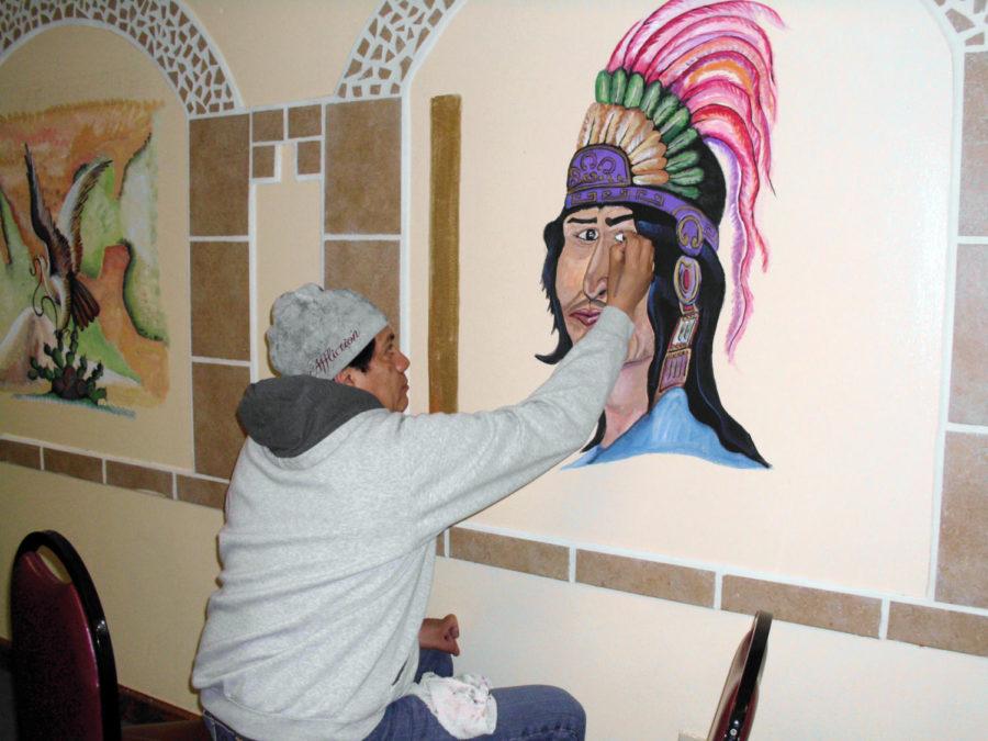 Hector Medina paints on the wall in Cazador on Feb. 5. Medina studied painting in Mexico City.

