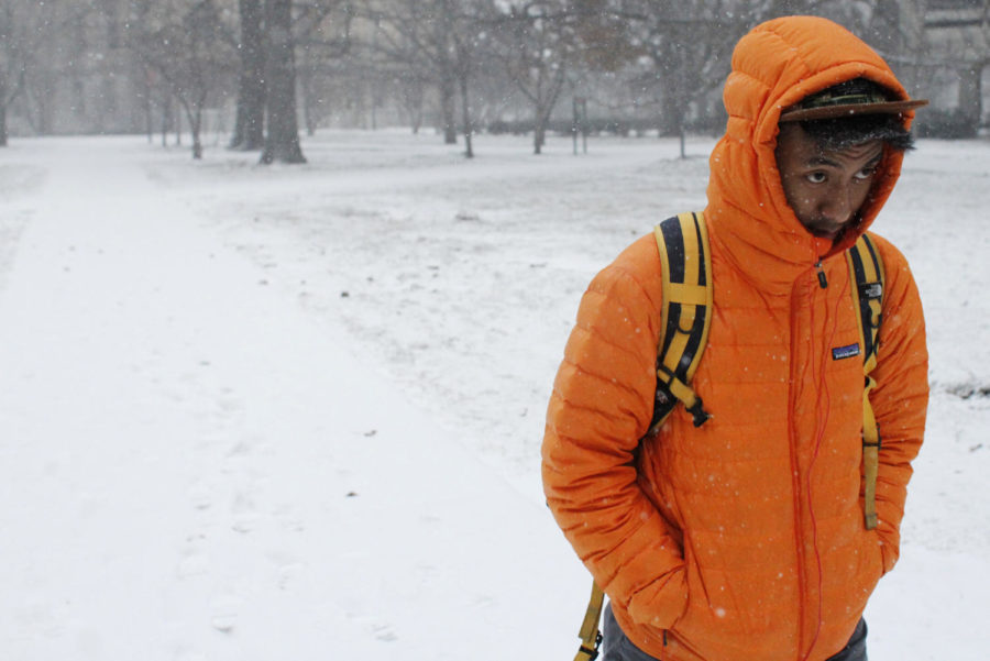 Tony Thonesavanh, junior in history, bears the snow and wind as he walks through Central Campus on Feb. 21. Ames is under a snow advisory until noon Friday. 
