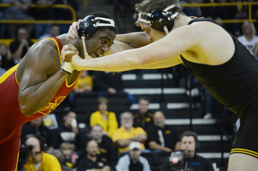 Matt Gibson grapples with Iowas Bobby Telford during the heavyweight match of Iowa States 32-3 loss to Iowa on Saturday, Dec. 1, at Carver-Hawkeye Arena.
