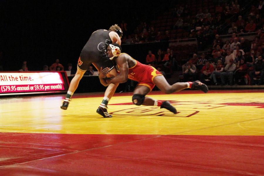 Redshirt sophomore Kyven Gadson attacks Oklahoma States Blake Rosholts legs in their match on Feb. 3, 2013 at Hilton Coliseum.  Gadson won his match 3-1 in the Cyclones 9-25 loss.
