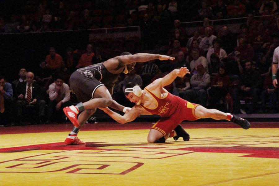 Redshirt junior Boaz Beard reaches for Oklahoma States Chris Chionuma in their match at Hilton Coliseum on Feb. 3, 2013.  Beard won his matchup with Chionuma with a score of 8-2 however the Cyclones fell 9-25.
