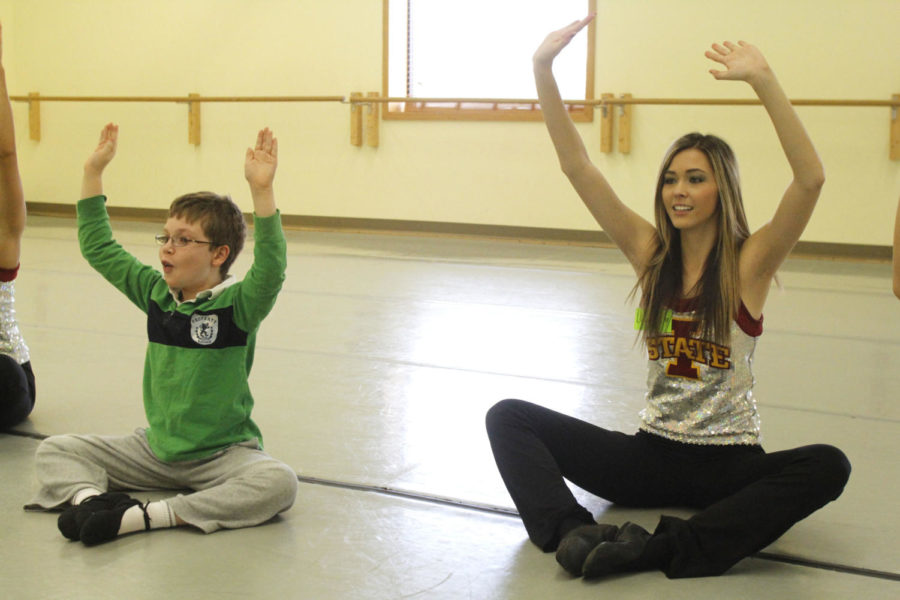 Member of the ISU Dance team, Lauren Albrecht, helps one of the dance students stretch before some exercises on March 3, 2013, for Dance Without Limits. The program helps children with special needs learn to dance and is part of Ballet Des Moines.
