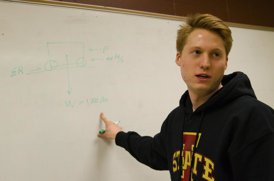 Tyler Cain, pioneer and president of the REV Club, explains the calculations for the clubs project, a vehicle that could run with a combination of water and solar energy. He came up with the calculation personally. He is a senior in civil engineering.

