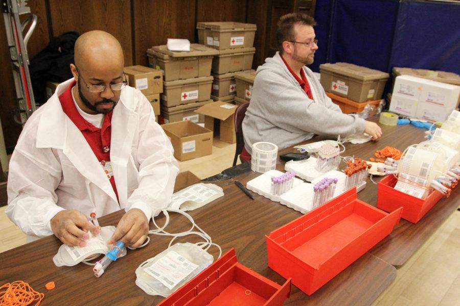 Courtland Van Arsdale (left) and Rob McAllister (right) both mobile unit assistants, assemble the collection sets for blood donations on March 28th, 2013 in the Great Hall of the Memorial Union.
