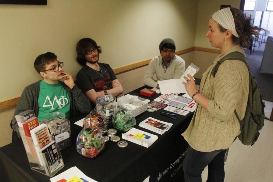 Miles Brainard, pictured left, sophomore in community and regional planning, president of Advocates for Sexual Health, Jonathan Yatckoske, sophomore in electrical engineering and member of Delta Lambda Phi, and Callen Ubeda, prevention specialist for Aids Project of Central Iowa, talk with Nicole Laurito, junior in animal ecology, about some sexual health tips during the free HIV testing event at the UDCC on March 26, 2013. 
