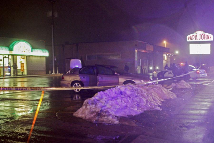 A car parked outside of Papa John's early Sunday morning, March 10, 2013, at 3335 Lincoln Way sits with its doors open as Ames police officers search the area. 
