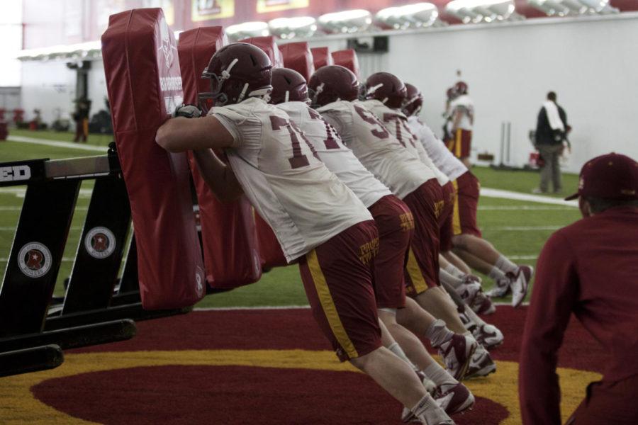 The ISU offensive line participates in a sled drill during spring football practice on Tuesday, March 26, 2013, at Bergstrom Indoor Training Facility.
