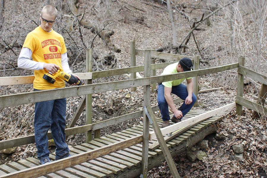 Senior Zach Mitchell and freshman Scott Miller, students in construction engineering, work on a bridge during the Veishea Service Day on April 6, 2013, at the former YMCA camp. The land is planned to be used as a place where students can go, and any campus organizations can use the lodge facililty located there.
