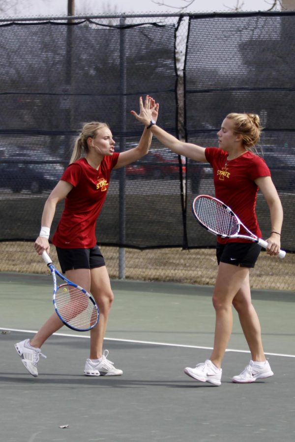 Caroline Andersen gives Emma Waites a high five during the doubles match for the loss against Oklahoma 4-2 on Friday, April 5, 2013.
